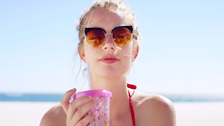 Donna che si gode un drink sulla spiaggia