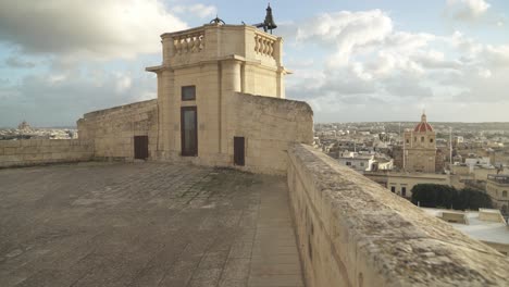 edificio en la fortaleza de cittadella con campanas mirando hacia la ciudad de victoria en un día soleado