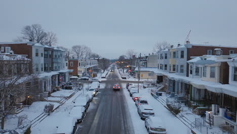 static aerial footage of a car driving down a snow covered street in west philadelphia, pennsylvania.