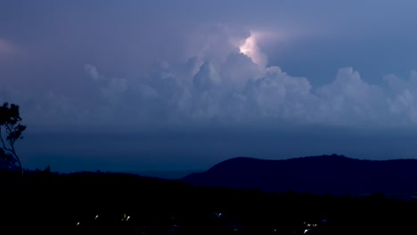 intermittent lightning brightens the nocturnal cloudscape