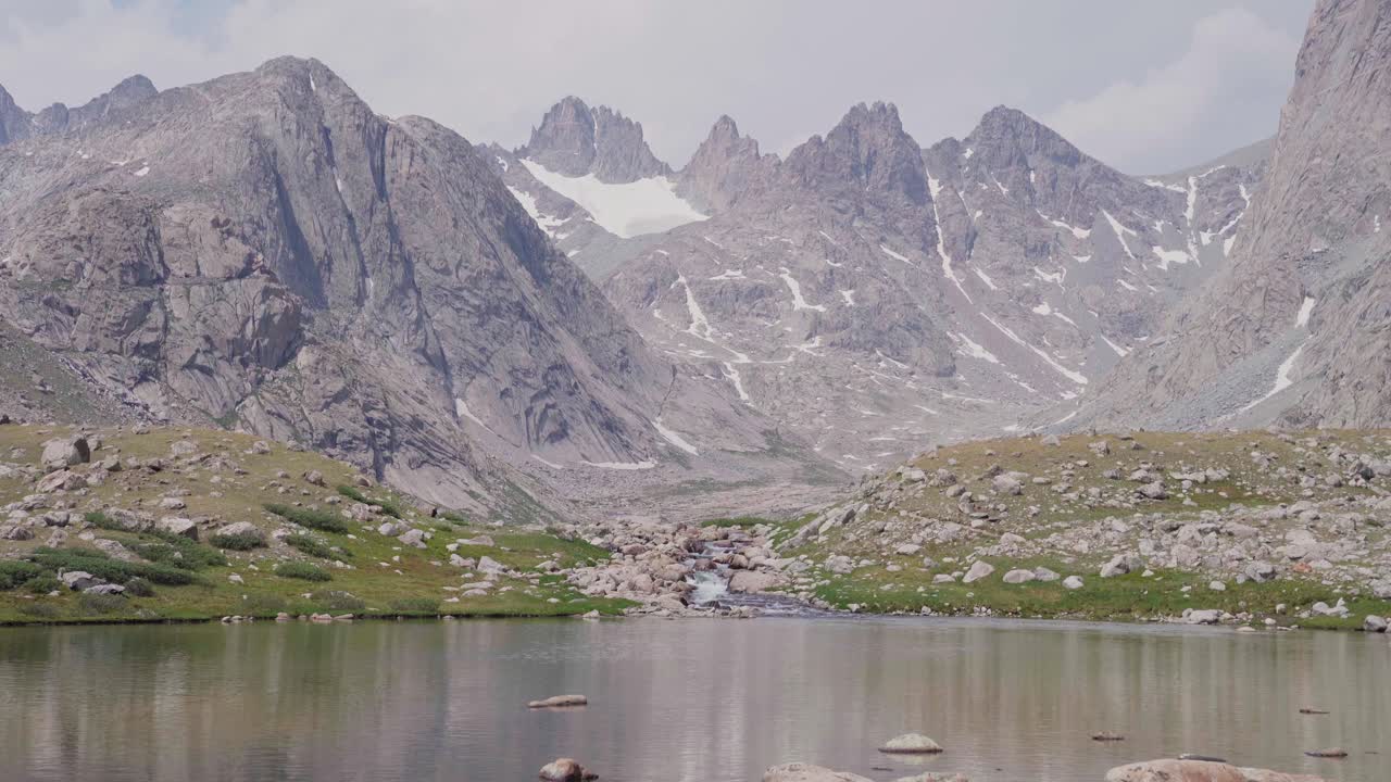 높은 산꼭대기 아래의 유역에서 오는 작은 알파인 폭포