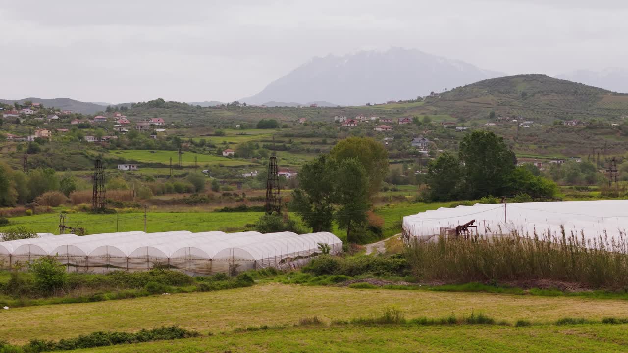 Green landscape near Berat, Albania with fields and distant oil field