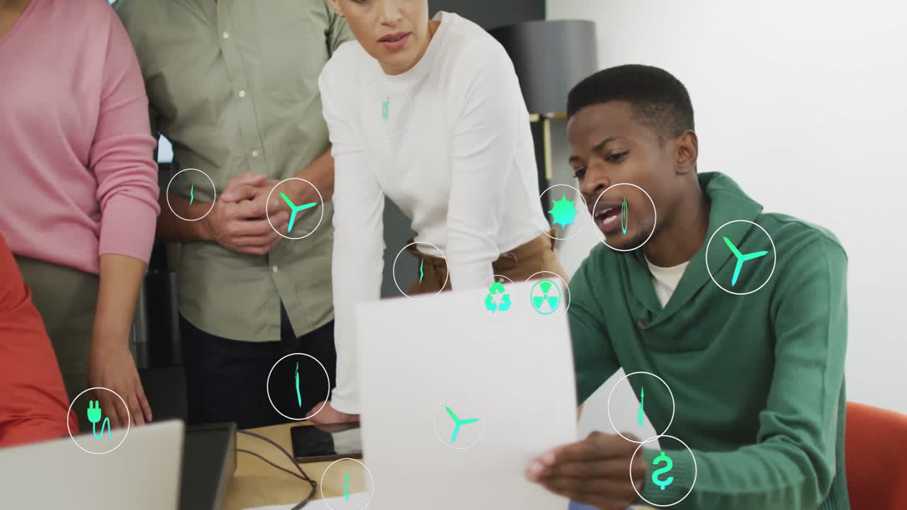 Analyzing documents, diverse team with green technology icons in office scene