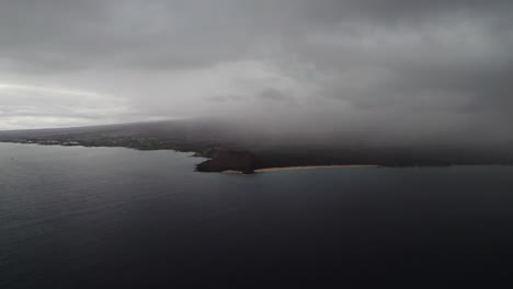 Epic-aerial-shot-flying-through-the-clouds-capturing-a-beautiful-South-Maui-beach,-Maui-County,-Hawaii