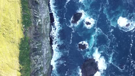 Tiefblaue-Wellen-Des-Nordatlantiks-Krachen-Gegen-Die-Hohen,-Von-Seevögeln-Bewohnten-Klippen-Der-Färöer-Inseln