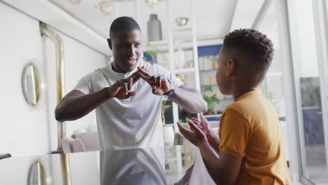 Video-of-happy-african-american-father-and-son-having-fun-at-home,-playing-finger-games