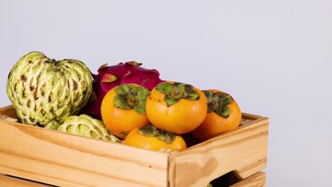 hand places custard apple in fruit basket