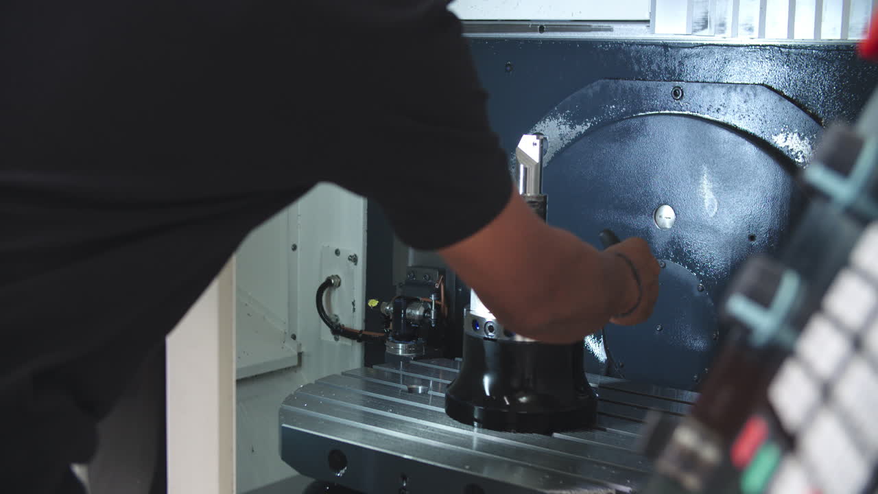 Male Engineer Operating CNC Machinery On Factory Floor