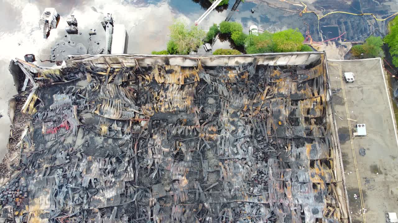 descendiendo por encima de la cáscara destripada de una fábrica química después de que el fuego arrasó