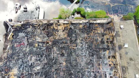 descending-above-the-gutted-shell-of-a-chemical-factory-after-fire-swept-through