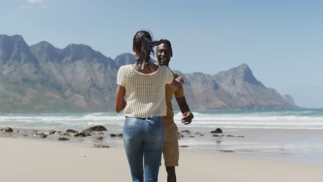 happy african american couple dancing together at the beach