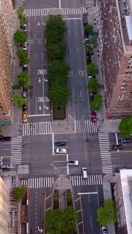 flying over the motorways and crossroads with few cars. multi-storied buildings towering over the streets. top view. vertical video