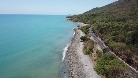 antena de drones avanzando sobre la playa de una isla tropical con agua azul