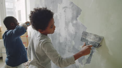 father and son repairing a wall