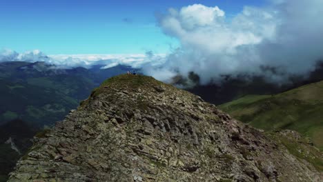 Circular-drone-shot-of-a-mountain-summit-during-summer