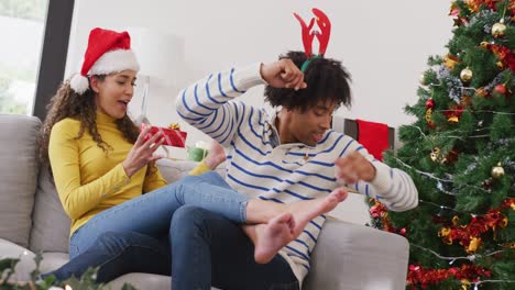 video of happy diverse couple exchanging christmas gifts at home