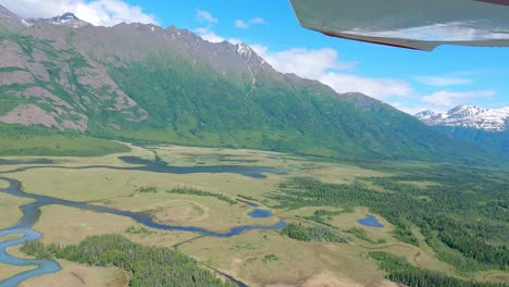 Small-airplane-flight-over-marsh-area-and-Leaf-Lake-with-mountains-in-the-distance-near-the-Knik-River,-east-of-Palmer-Alaska