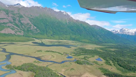 pequeño vuelo en avión sobre la zona pantanosa y el lago de hojas con montañas a lo lejos cerca del río knik, al este de palmer alaska