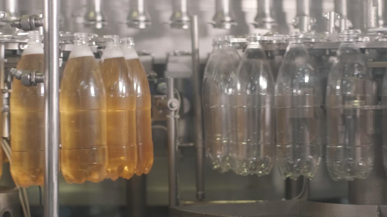 la máquina de llenado automático vierte agua en botellas de plástico para mascotas en una moderna planta de bebidas