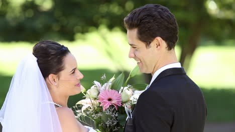 Happy-newlyweds-standing-in-the-park