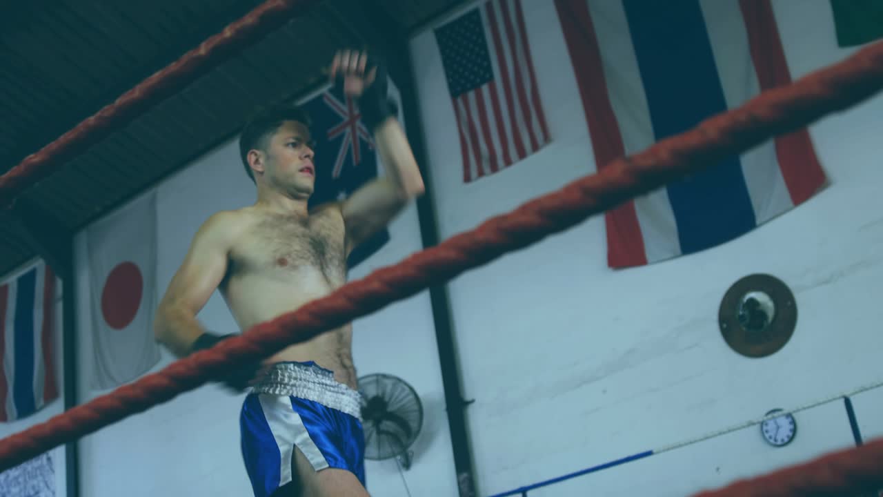 Male boxer planting feet practicing high round kick across ropes charts over boxer pivoting guard