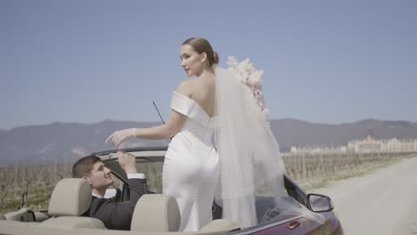 bride and groom in a convertible car