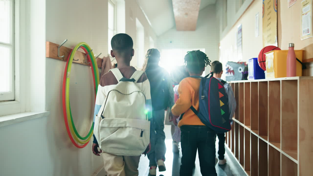Children Walking in School Hallway with Backpacks