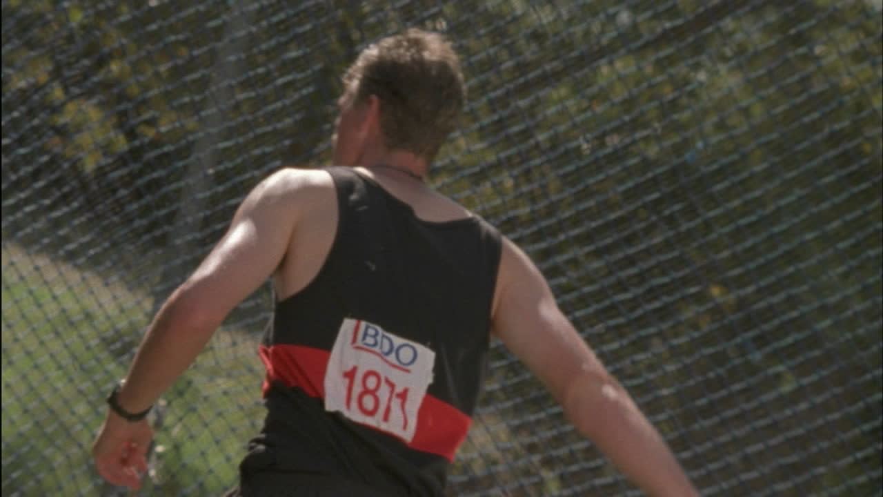 한 남자가 빙글빙글 돌며 디스크를 던집니다.