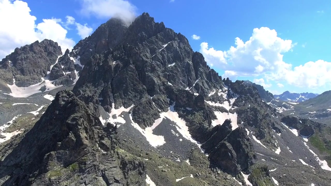 Vista aerea di una maestosa cima montuosa rocciosa con chiazze di neve