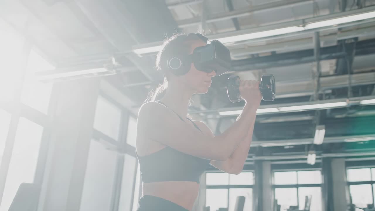 Fitness driven female athlete wearing VR headset, performing strength training with dumbbells in modern gym, showcasing technological innovation and personal wellness