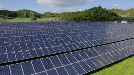 Aerial-slow-pan-of-solar-panels-in-green-field-on-a-sunny-day