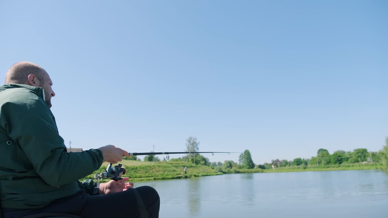 장애인 남자가 호수에서 시를 하고 있다. 체어. 캠핑. 여름