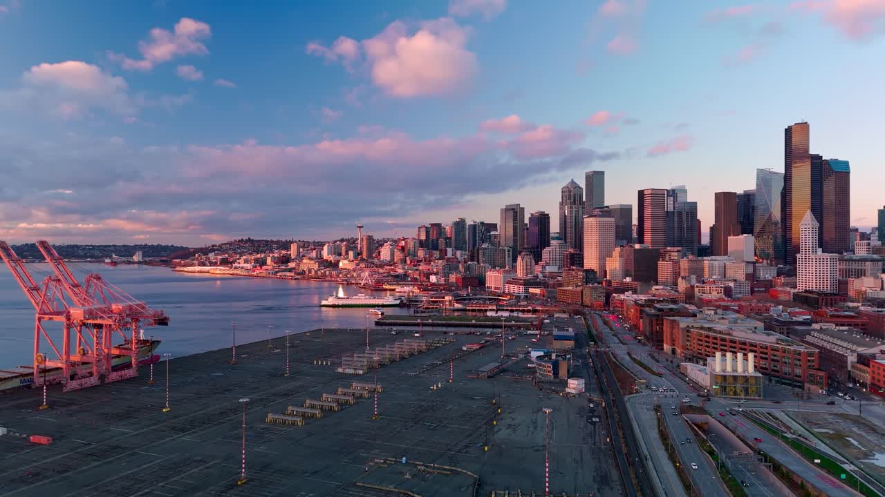 Rising drone shot over Seattle's port district during a colorful sunset
