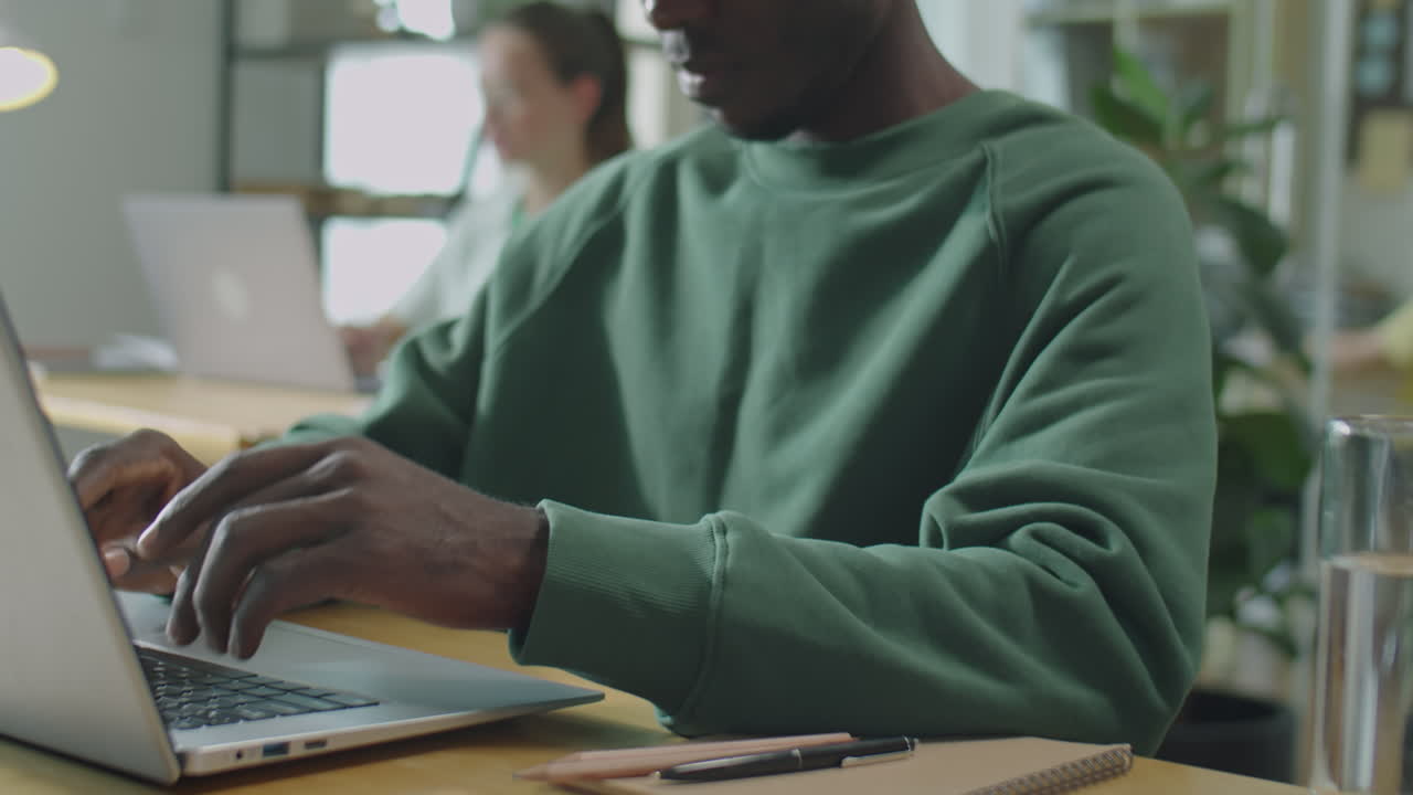 Black Man Typing on Laptop at Office Desk