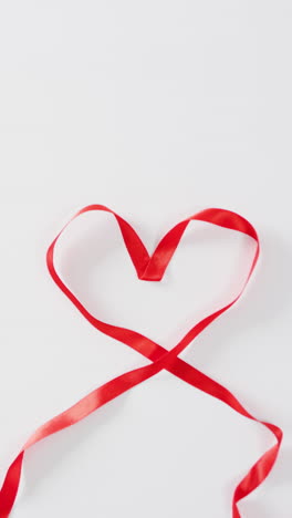 video vertical de primer plano de la cinta del corazón sobre un fondo blanco