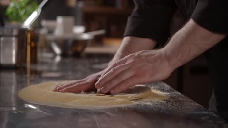 el chef preparando la masa de la pizza