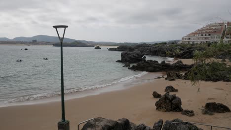 calm beach view with rocks and cloudy skies at quejo beach, cantabria, spain
