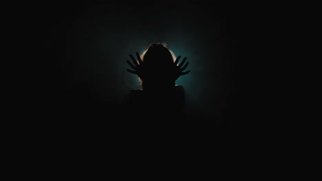 slow motion shot of woman's silhouette dancing in front of a backlight