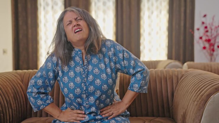 mujer india de edad que sufre de dolor de estómago