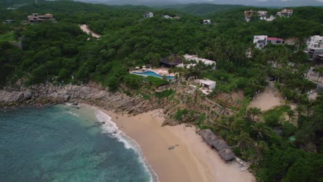 Luftdrohnenaufnahme-Eines-Strandes-In-Mexiko,-Huatulco-Oaxaca,-Während-Der-Sommerferien,-Mit-Sanften-Wellen,-Die-Das-Ufer-Umspülen,-Und-Einem-Unberührten-Blauen-Meer