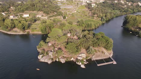 Aerial-rotation-over-Lovers-island-River-landscape,-Castelo-de-Paiva---Portugal