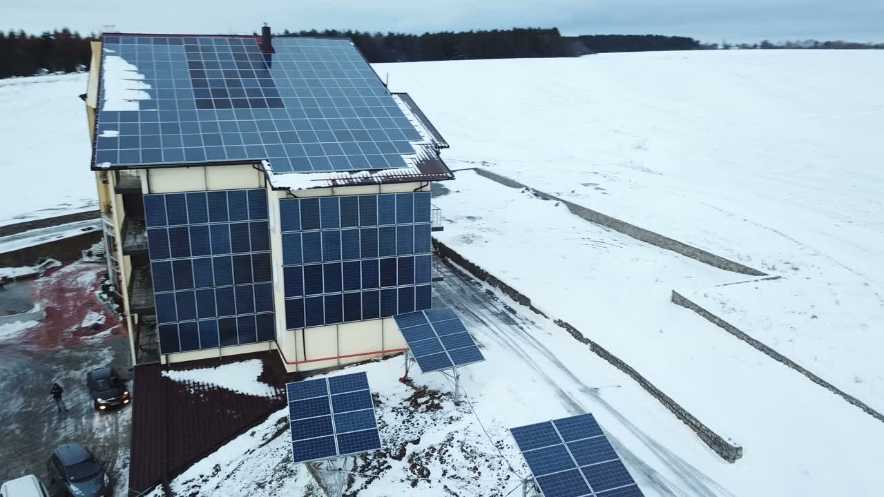 Aerial solar farm low flight in winter. Series of solar panels covered with snow.