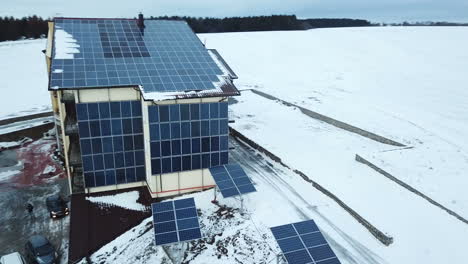 aerial solar farm low flight in winter. series of solar panels covered with snow.