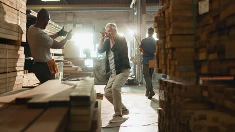 men in a lumber warehouse high-fiving