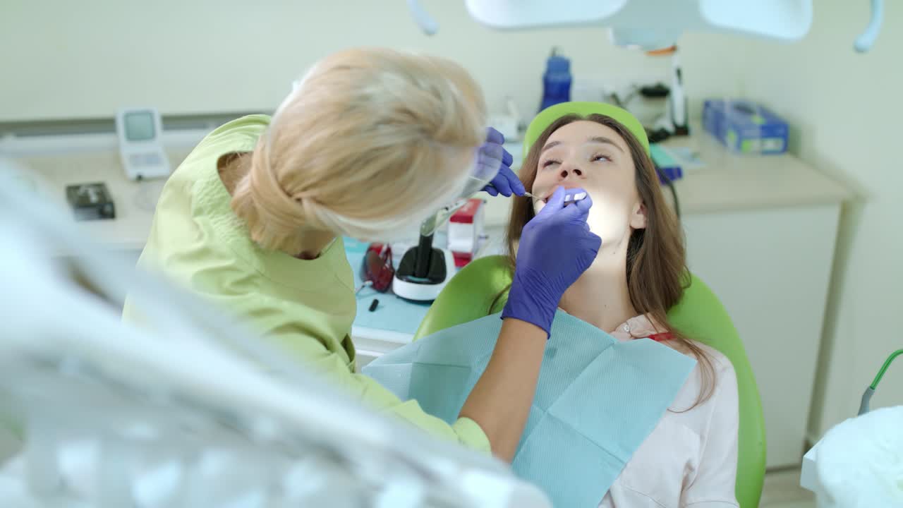 Woman dentist taking out tampon from patient mouth. Toothache treatment ...