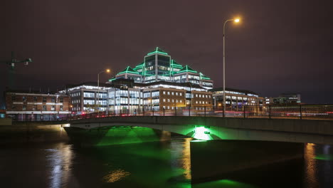 time lapse of ulster bank building illuminated at night with traffic on the bridge over liffey river in dublin city in ireland