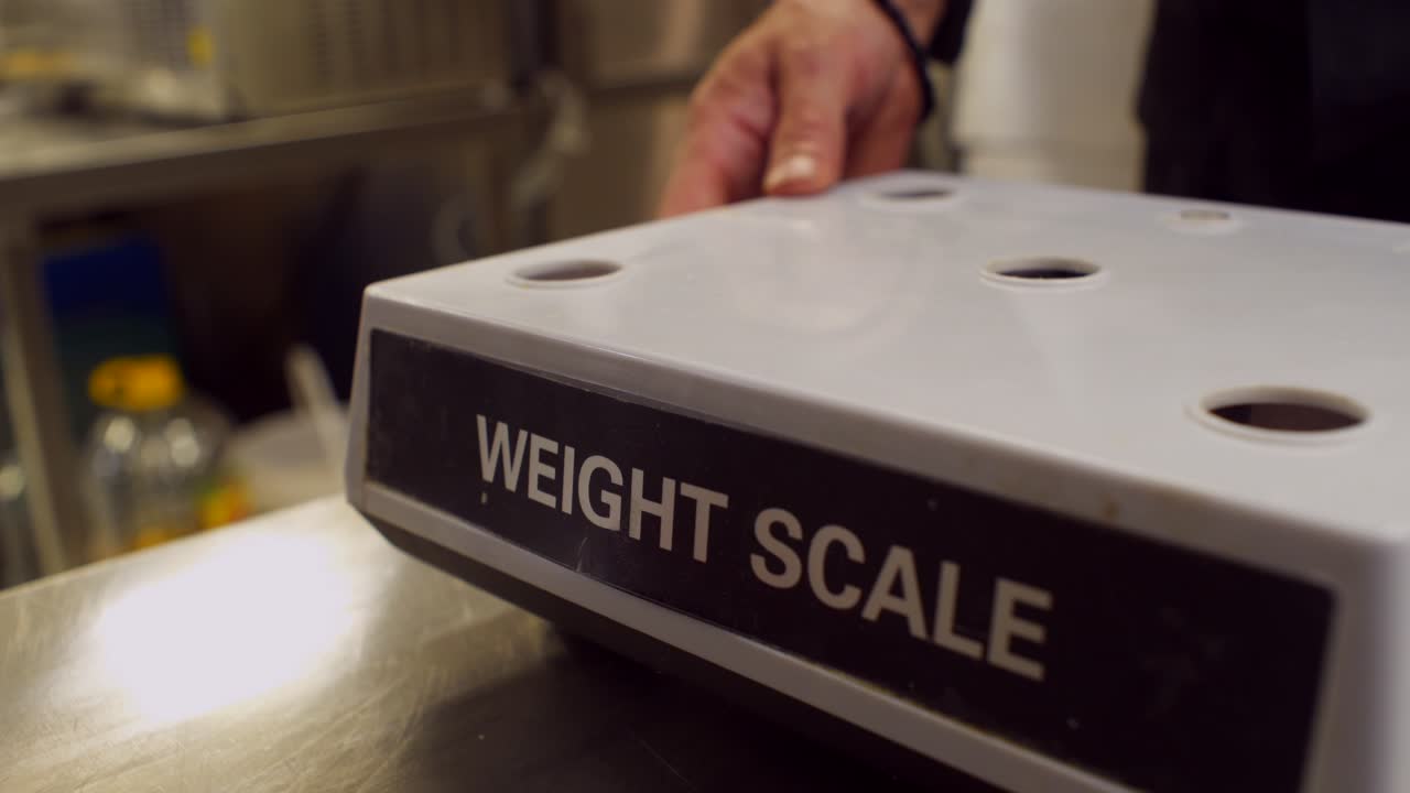 Close up on man's hands assembling a kitchen weight scale after battery replacement and maintenance, 4K