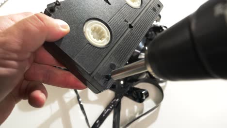 desenrollar un cassette vhs con carretes y cinta en el interior