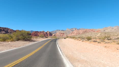 cars driving down a desert road