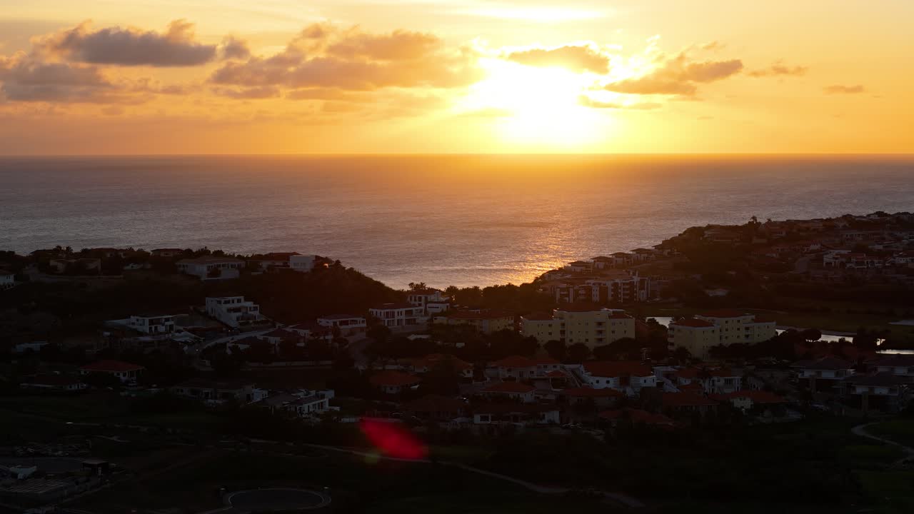 카리브해 오션뷰 리조트 위에서 해가 지는 동안 황금색으로 빛나는  ⁇ 은 구름